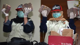 Petugas KPK menunjukkan barang bukti uang yang diamankan dari operasi tangkap tangan (OTT) di Cianjur saat konferensi pers di Jakarta, Rabu (12/12). [ANTARA FOTO/Akbar Nugroho Gumay]