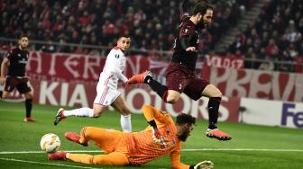 Pemain Milan Gonzalo Higuain menghindari kiper Olympiakos Jose Sa selama pertandingan sepakbola Liga Europa grup F antara Olympiakos melawan AC Milan di Stadion Karaiskaki, Piraeus, Yunani, Jumat (14/12). [ARIS MESSINIS / AFP]