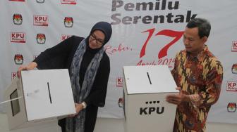 Komisioner KPU RI, Evi Novida Ginting Manik (kiri) dan Pramono Ubaid Tanthowi (kanan) menunjukan kotak suara bermaterial karton kedap air dan transparan di Kantor KPU Pusat, di Jakarta, Jumat (14/12). [Suara.com/Fakhri Hermansyah]