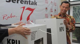 Komisioner KPU RI, Evi Novida Ginting Manik (kiri) dan Pramono Ubaid Tanthowi (kanan) menunjukan kotak suara bermaterial karton kedap air dan transparan di Kantor KPU Pusat, di Jakarta, Jumat (14/12). [Suara.com/Fakhri Hermansyah]