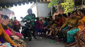 Salut, Pengendara Ini Pilih Dorong Motor daripada Ganggu Upacara Adat