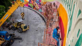 Pekerja menyelesaikan gambar mural bertema tokoh pewayangan di proyek Overpass Manahan, Solo, Jawa Tengah, Minggu (16/12). ANTARA FOTO/Mohammad Ayudha