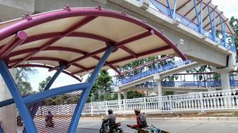 Pejalan kaki melintasi Jembatan Penyeberangan Orang (JPO) bernuansa Betawi di Jalan Tubagus Angke, Jakarta Utara, Senin (17/12). [Suara com/Fakhri Hermansyah]