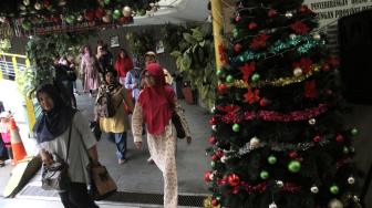 Pejalan kaki melintasi Terowongan Penyeberangan Orang (TPO) Kota Tua yang dihiasi pernak-pernik Natal, Jakarta Barat, Rabu, (19/12). [Suara com/Fakhri Hermansyah]