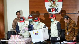 Wakil Ketua KPK saut Sitomorang dan Juru Bicara Febry Diansah bersama penyidik memperlihatkan barang bukti kasus suap terkait penyaluran dana hibah kepada KONI saat konferensi pers ott pejabat Kemenpora di Gedung KPK, Jakarta, Rabu (19/12). [Suara.com/Muhaimin A Untung]