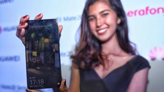 Model mencoba smartphone terbaru Mate 20 Series dari Huawei saat peluncuran perdana di Hotel Westin, Jakarta, Rabu (19/12). [Suara.com/Muhaimin A Untung]