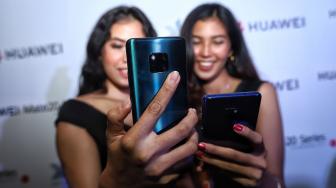 Model mencoba smartphone terbaru Mate 20 Series dari Huawei saat peluncuran perdana di Hotel Westin, Jakarta, Rabu (19/12). [Suara.com/Muhaimin A Untung]