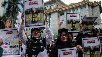 Pengunjuk rasa dari berbagai organisasi Islam menggelar aksi solidaritas terhadap Muslim Uighur di depan Kedubes Cina, Jakarta, Jumat (21/12). ANTARA FOTO/Putra Haryo Kurniawan