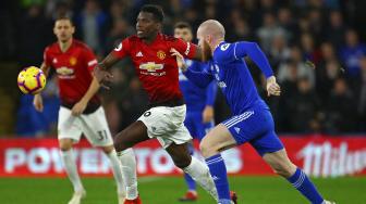 Gelandang Manchester United Paul Pogba bersaing dengan gelandang Cardiff City Aron Gunnarsson selama pertandingan sepak bola Liga Premier Inggris antara Cardiff City melawan Manchester United  di Stadion Cardiff, Cardiff, Inggris, Minggu (23/12). [Geoff CADDICK / AFP]