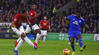 Striker Manchester United Anthony Martial menembak untuk mencetak gol ketiga mereka selama pertandingan sepak bola Liga Inggris antara Cardiff City melawan Manchester United  di Stadion Cardiff, Cardiff, Inggris, Minggu (23/12). [Geoff CADDICK / AFP]
