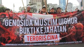 Sejumlah masyarakat Pembela Tauhid menggelar aksi solidaritas terhadap Muslim Uighur di Hari Bebas Kendaraan Bermotor (HBKB) di Bundaran HI, Jakarta Pusat, Minggu (23/11).[Suara.com/Fakhri Hermansyah]