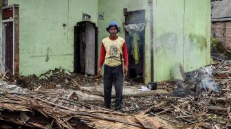 Warga berdiri di depan rumahnya yang hancur diterjang gelombang tsunami Selat Sunda di Kecamatan Sumur, Pandeglang, Banten, Selasa (25/12). [ANTARA FOTO/Muhammad Adimaja]