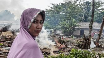 Warga berdiri di depan rumahnya yang hancur diterjang gelombang tsunami Selat Sunda di Kecamatan Sumur, Pandeglang, Banten, Selasa (25/12). [ANTARA FOTO/Muhammad Adimaja]