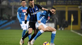 Pemain belakang Napoli Nikola Maksimovic menahan gelandang Inter Milan Ivan Perisic selama pertandingan sepak bola Serie A Italia antara Inter Milan melawan Napoli di Stadion Giuseppe Meazza, Milan, Italia, Kamis (27/12). [Marco BERTORELLO / AFP]