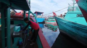 Nelayan beraktifitas di perahu nelayan saat bersandar di Pelabuhan Muara Angke, Jakarta, Kamis (27/12). [Suara.com/Muhaimin A Untung]