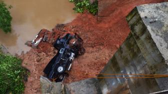 Sebuah mobil jatuh ke jurang setelah badan jalan tepi jembatan yang dilewatinya ambles di Kampung Leuwi Jaksi, Cimarga, Lebak, Banten, Rabu (26/12). [ANTARA FOTO/Muhammad Bagus Khoirunas]