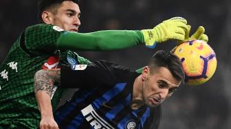 Pemain belakang Napoli Nikola Maksimovic menahan gelandang Inter Milan Ivan Perisic selama pertandingan sepak bola Serie A Italia antara Inter Milan melawan Napoli di Stadion Giuseppe Meazza, Milan, Italia, Kamis (27/12). [Marco BERTORELLO / AFP]