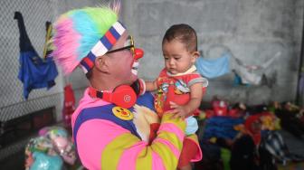 Badut dari Aku Badut Indonesia menghibur anak korban bencana tsunami di pengungsian Labuan, Pandeglang, Banten, Kamis (27/1).[ANTARA FOTO/Akbar Nugroho Gumay]