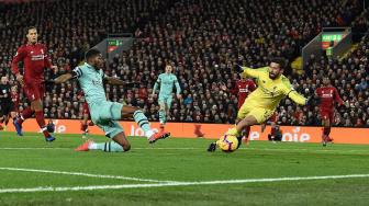 Gelandang Arsenal Ainsley Maitland-Niles mencetak gol pembuka melewati kiper Liverpool Brasil Alisson Becker selama pertandingan sepak bola Liga Premier Inggris antara Liverpool melawan Arsenal di Stadion  Anfield, Liverpool, Inggris, Minggu (30/12). [Paul ELLIS / AFP]
