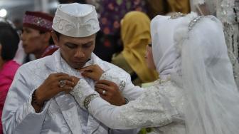 Pasangan pengantin mengikuti nikah massal di Thamrin Park ride, Jakarta, Senin (31/12). [Suara.com/Muhaimin A Untung]