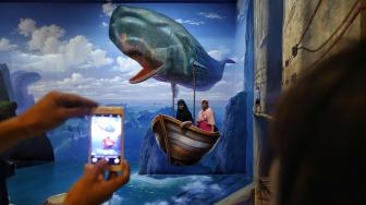 Pengunjung menikmati suasana mural dan ilusi Museum Magic Art 3D, di kawasan wisata Kota Tua, Jakarta, Senin (31/12). [Suara.com/Muhaimin A Untung]