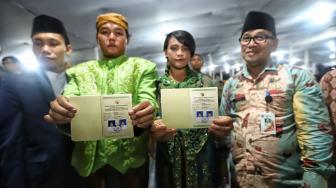 Pasangan pengantin mengikuti nikah massal di Thamrin Park ride, Jakarta, Senin (31/12). [Suara.com/Muhaimin A Untung]