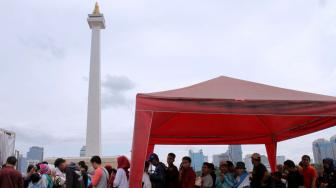 Warga memadati kawasan Monumen Nasional (Monas), Jakarta Pusat, Selasa (1/1). [Suara.com/Fakhri Hermansyah]