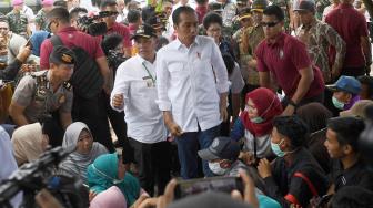 Presiden Joko Widodo (tengah) berdialog dengan warga ketika mengunjungi lokasi terdampak tsunami Selat Sunda di Desa Kunjir, Rajabasa Lampung Selatan, Lampung, Rabu (2/1). [ANTARA FOTO/Wahyu Putro]