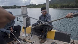 Petugas BMKG memasang alat pengukur ketinggian air atau "water level" saat berlangsung erupsi Gunung Anak Krakatau (GAK) di Pelabuhan Pulau Sebesi, Lampung Selatan, Lampung, Selasa (1/1). [ANTARA FOTO/Sigid Kurniawan]