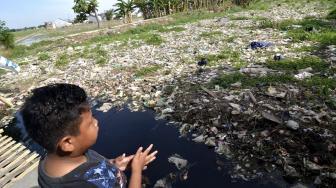 Suasana Kali Pisang Batu yang dipenuhi sampah di desa Pahlawan Setia, Bekasi, Jawa Barat, Jumat (4/1).   [Suara.com/Fakhri Hermansyah]