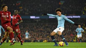 Pemain tengah Manchester City  Leroy Sane menembak untuk mencetak gol kedua mereka selama pertandingan sepak bola Liga Premier Inggris antara Manchester City melawan Liverpool di Etihad Stadium, Manchester, Inggris, Jumat (4/1). [Oli SCARFF / AFP]