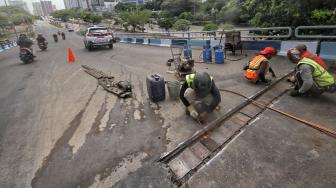 Petugas melakukan perbaikan Jembatan layangnyang renggang di Jalan Layang, Jalan Industri Raya, Kemayoran, Jakarta Pusat, Minggu (6/1). [Suara.com/Muhaimin A Untung] 