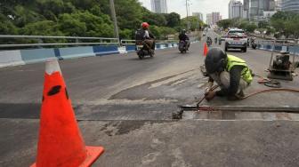 Petugas melakukan perbaikan Jembatan layangnyang renggang di Jalan Layang, Jalan Industri Raya, Kemayoran, Jakarta Pusat, Minggu (6/1). [Suara.com/Muhaimin A Untung] 