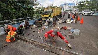 Petugas melakukan perbaikan Jembatan layangnyang renggang di Jalan Layang, Jalan Industri Raya, Kemayoran, Jakarta Pusat, Minggu (6/1). [Suara.com/Muhaimin A Untung] 