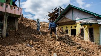 Warga berjalan di antara rumah yang terkena dampak bencana longsor di Kampung Garehong, Desa Sirnaresmi, Cisolok, Kabupaten Sukabumi, Jawa Barat, Sabtu (5/1). ANTARA FOTO/Nurul Ramadhan