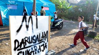 Siswa SD Yayasan Madrasah Ibtidaiyah (MI) Darussalam Sukaraja datang ke sekolah yang menggunakan tenda darurat di Desa Sukaraja, Kabupaten Lampung Selatan, Lampung, Senin (7/1). ANTARA FOTO/Ardiansyah