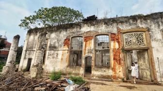 Warga memperhatikan bangunan Rumah Cimanggis yang saat ini dijadikan situs cagar budaya di Cimanggis, Depok, Jawa Barat, Minggu (13/1). [Suara.com/Muhaimin A Untung]