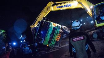 Sejumlah petugas dibantu warga berusaha mengeluarkan korban yang terjepit di dalam sebuah kendaraan minibus akibat tertimpa truk bermuatan batu bara di Jalan Raya Siliwangi, Parungkuda, Kabupaten Sukabumi, Jawa Barat, Sabtu (12/1). ANTARA FOTO/Nurul Ramadhan