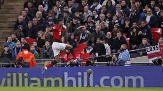 
Striker Manchester United Marcus Rashford merayakan golnya setelah mencetak gol pembuka pertandingan sepak bola Liga Premier Inggris antara Tottenham Hotspur melawan Manchester United di Stadion Wembley, London,Inggris, Minggu (13/1). [Adrian DENNIS / AFP]