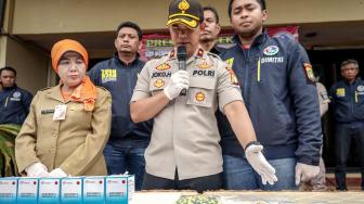 Kapolsek Kembangan, Kompol Joko Handono (tengah) bersama Kasudin Pendidikan Wilayah II JAKBAR, Uripasih (kiri) dan Kanit Reskrim Polsek Kembangan, IPTU Dimitri Mahendra (kanan) Saat melakukan rilis penangkapan gudang narkoba sekolah di Polres Jakarta Barat, Selasa (15/1). [Suara.com/Fakhri Hermansyah]

