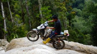 Pengojek 'Rampi' melewati jalan berlubang menuju Kecamatan Rampi, Kabupaten Luwu Utara, Sulawesi Selatan, Minggu (13/01). [ANTARA FOTO/Sahrul Manda Tikupadang]