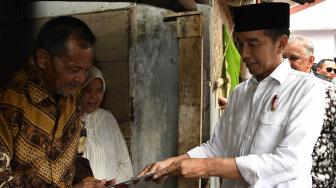 Presiden Joko Widodo (kanan) berbincang dengan penerima fasilitas pemasangan listrik gratis di Kampung Pasar Kolot, Garut, Jawa Barat, Jumat (18/1). [ANTARA FOTO/Puspa Perwitasari]