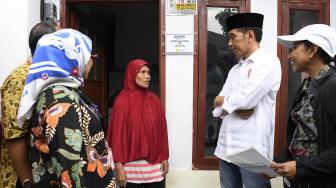 Presiden Joko Widodo (kanan) berbincang dengan penerima fasilitas pemasangan listrik gratis di Kampung Pasar Kolot, Garut, Jawa Barat, Jumat (18/1). [ANTARA FOTO/Puspa Perwitasari]