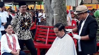 Presiden Joko Widodo didampingi Ibu Negara Iriana Joko Widodo saat mengikuti potong rambut massal di area wisata Situ Bagendit, Garut, Jawa Barat, Sabtu (19/1). [Suara.com/Ummi Hadyah Saleh]