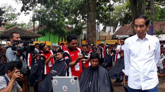 Presiden Joko Widodo saat melihat potong rambut massal di area wisata Situ Bagendit, Garut, Jawa Barat, Sabtu (19/1). [Suara.com/Ummi Hadyah Saleh]