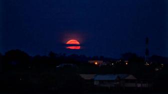 Bulan purnama terang memerah dan besar saat fajar jelang terjadi gerhana bulan dan fenomena Supermoon terlihat diatas langit Kota Lhokseumawe, Aceh, Senin (21/1). ANTARA FOTO/Rahmad