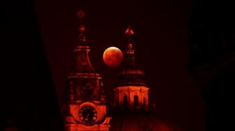 
Bulan purnama terang memerah dan besar saat terjadi gerhana bulan dan fenomena Supermoon di Ceko, Senin (21/1). [Michal CIZEK / AFP]