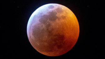 Bulan purnama terang memerah dan besar saat terjadi gerhana bulan dan fenomena Supermoon di Miami, Florida, Amerika Serikat, Senin (21/1). [Gaston De Cardenas / AFP]