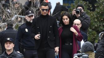 Pemain Juventus Cristiano Ronaldo bersama kekasihnya Georgina Rodriguez saat menghadiri sidang dugaan penggelapan pajak di Kota Madrid, Spanyol, Selasa (22/1). [PIERRE-PHILIPPE MARCOU / AFP]