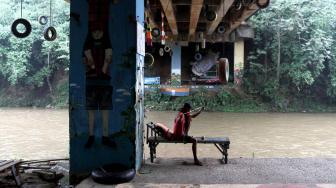 Anggota Komunitas Ciliwung Depok (KCD)  saat membuat kerajinan tangan dengan menggunakan bambu bekas di sekitar kawasan bantaran Sungai Ciliwung, Depok Jawa Barat, Jum'at (25/1). [Suara.com/Fakhri Hermansyah]